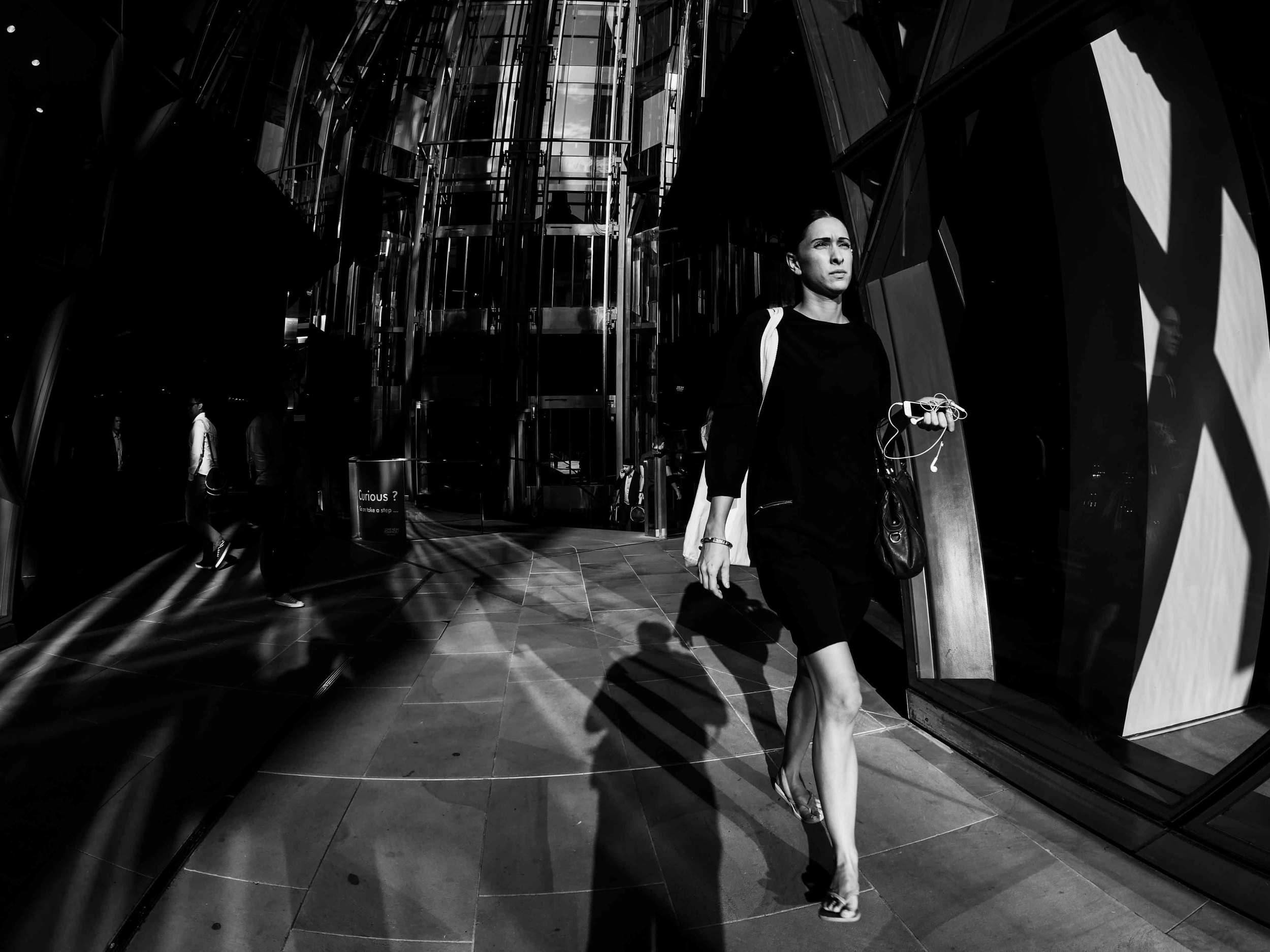 A photograph of a young lady walking out the One New Change shopping mall opposite St. Pauls in London, captured using a Fisheye lens.