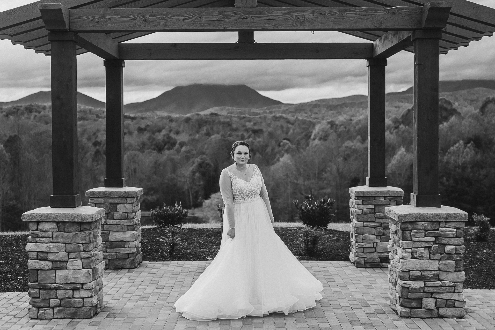 Bride_in_wedding_dress_on_mountaintop_at_glass_hill_venue_Ynchburg_virginia_overlooking_blue_ridge_mountain_by_jonathan_and_hannah_photography