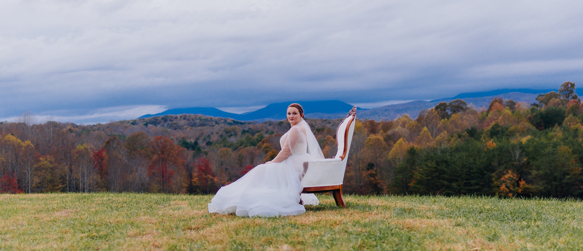Bride_in_wedding_dress_on_mountaintop_at_glass_hill_venue_Ynchburg_virginia_overlooking_blue_ridge_mountain_by_jonathan_and_hannah_photography