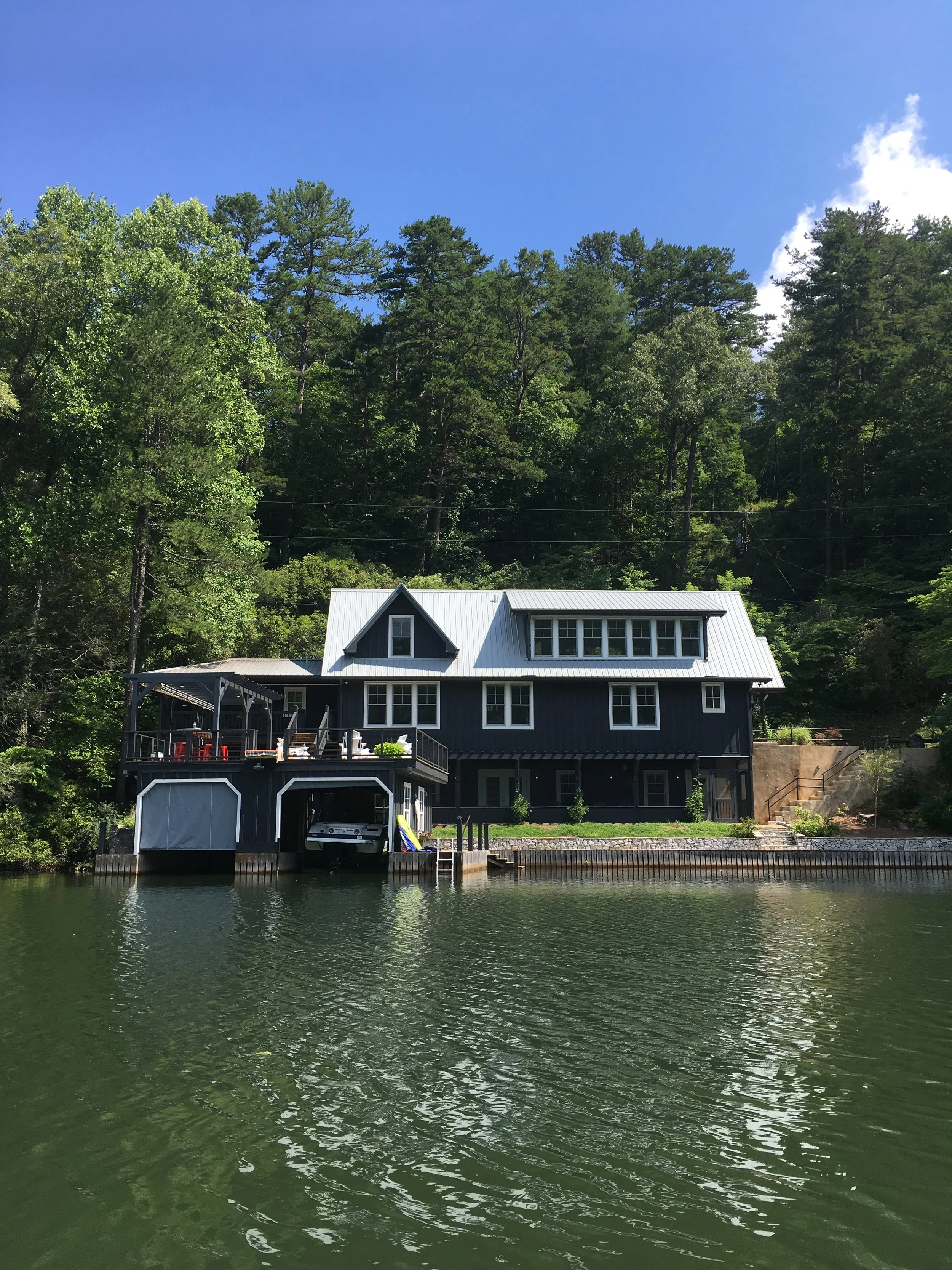 Lakeside elevation - bedroom and playroom on the top level, three bedrooms across the middle level, kitchen and family room on the lowest level