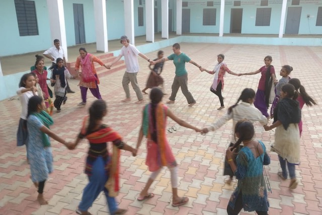 Owen and Olivia playing lion and goat with the girls at the school.