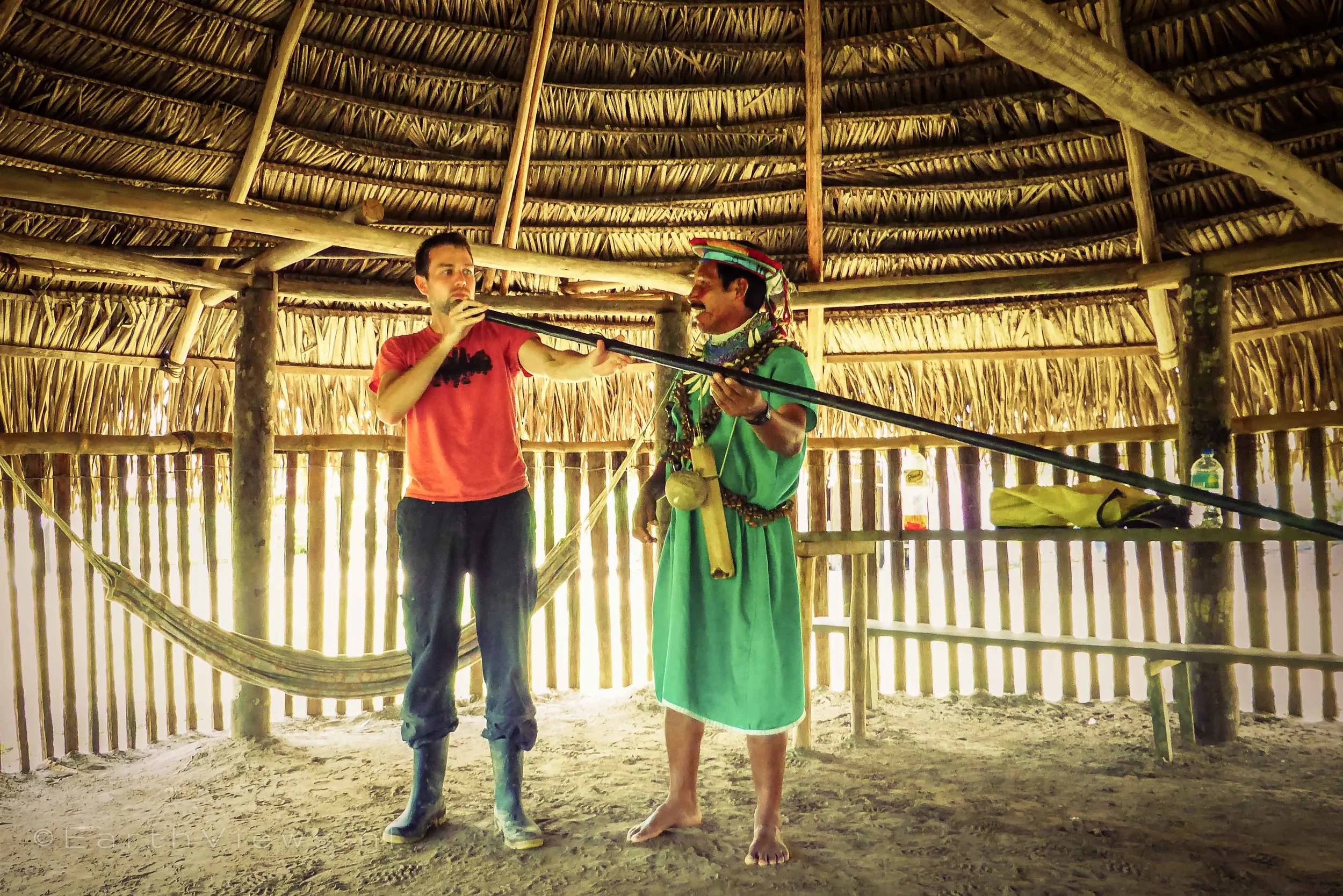 The shaman let me blow an arrow with a blowgun. I aimed at an Amazonian piece of fruit, and missed!