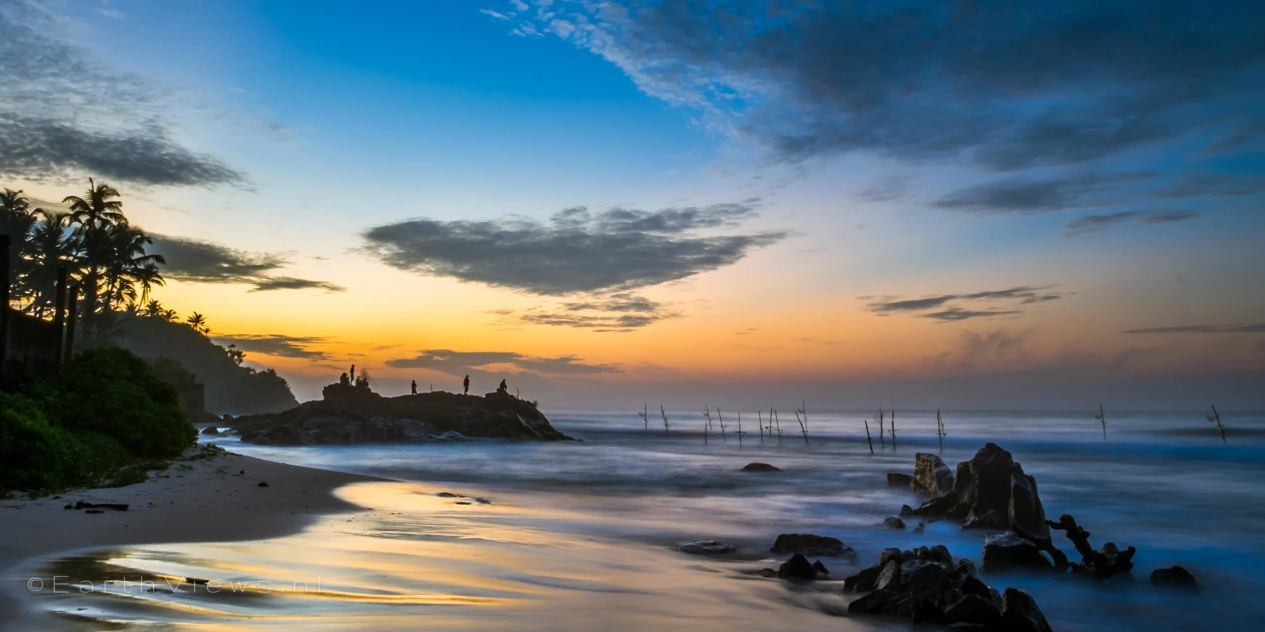 A wide angle view across the beach of Weligama, Sri Lanka during morning twilight.
