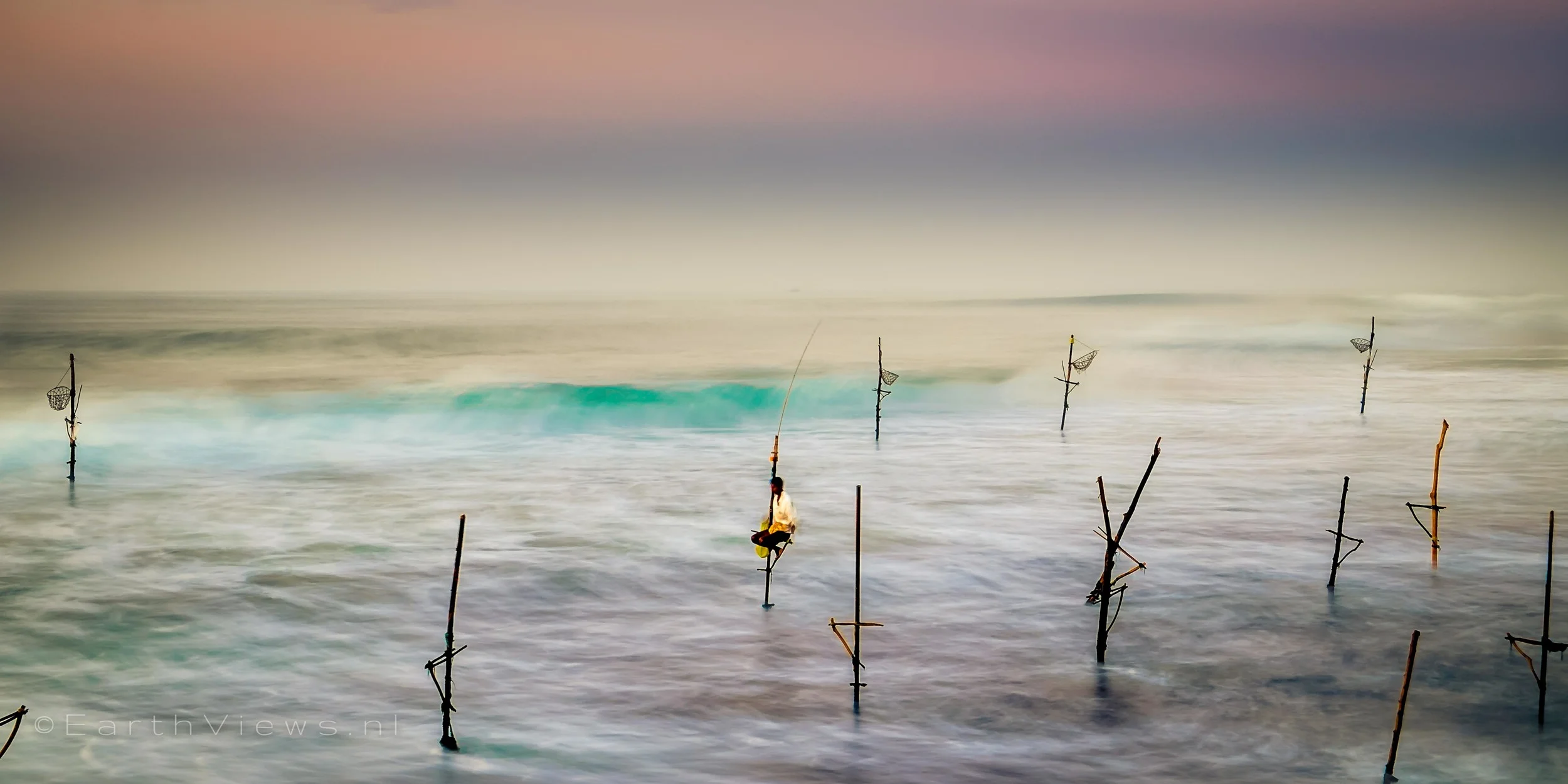 Stilt fishermen at the beach of Weligama, Sri Lanka.