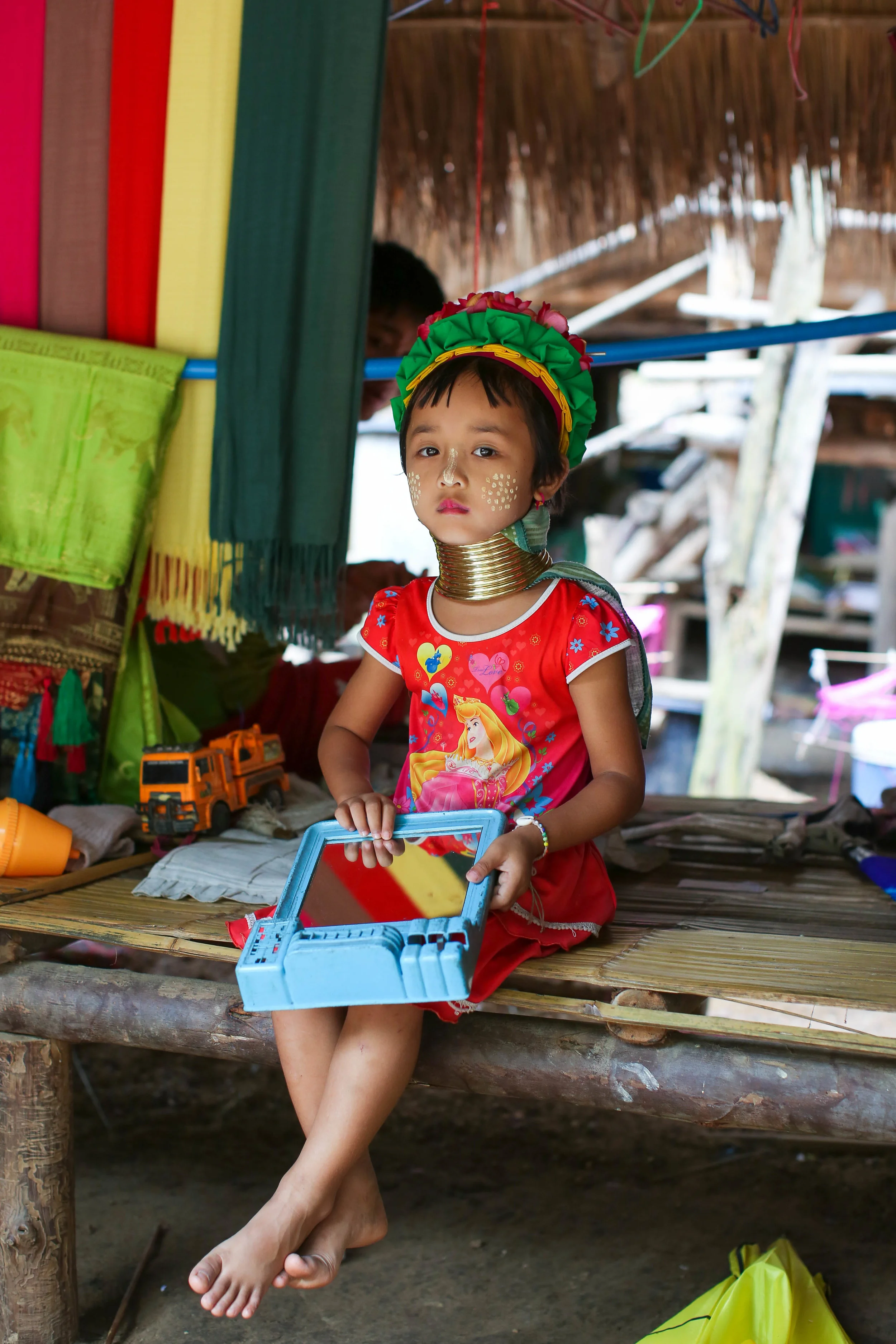 A young girl paused from playing for a photo. The Long Neck Tribe. Chiang Mai, Thailand