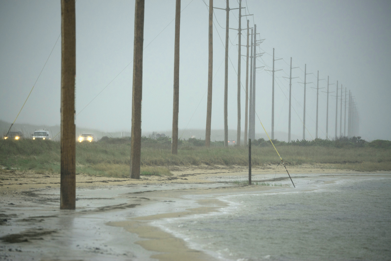 Receding shoreline threaten utility poles and Highway 12 near Avon, North Carolina, at the Haulover Day Use Area of the Cape Hatteras National Seashore.