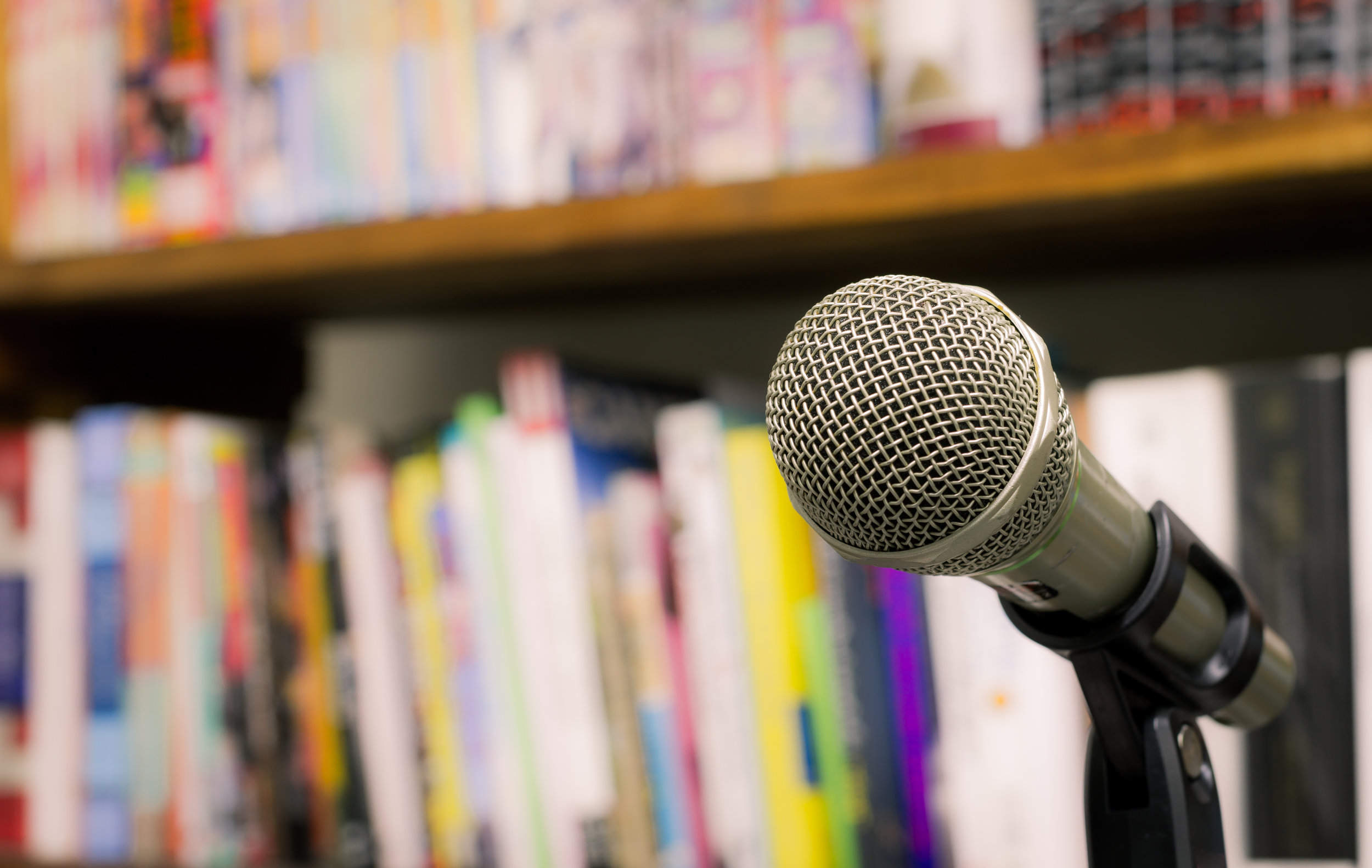 Microphone On The Background Of Blurred Bookshelf In Library. S