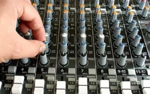 a picture of someone adjusting 80Hz on a Mackie Analog Mixing Desk
