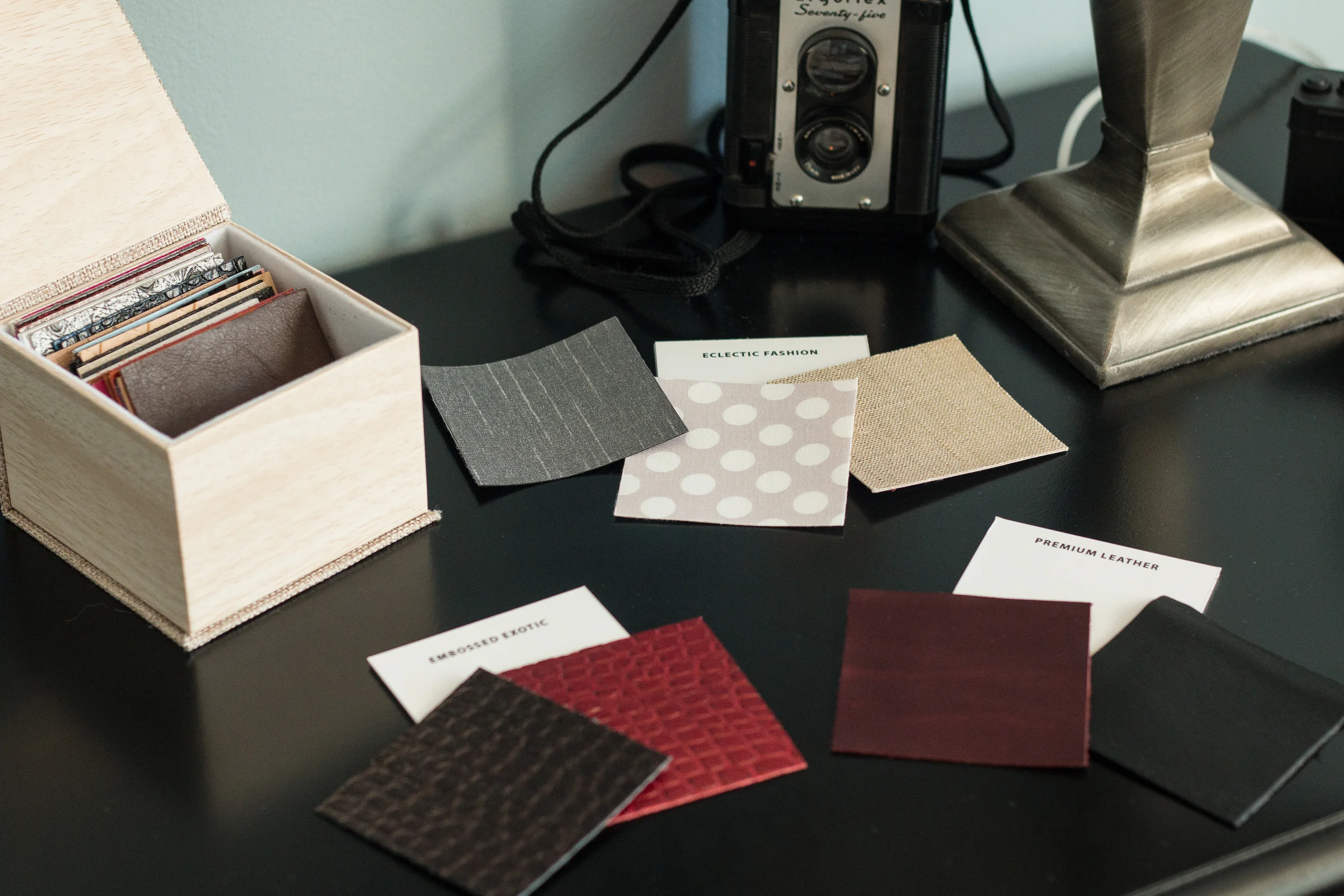 Custom photo keepsake boxes and cover swatches on table.