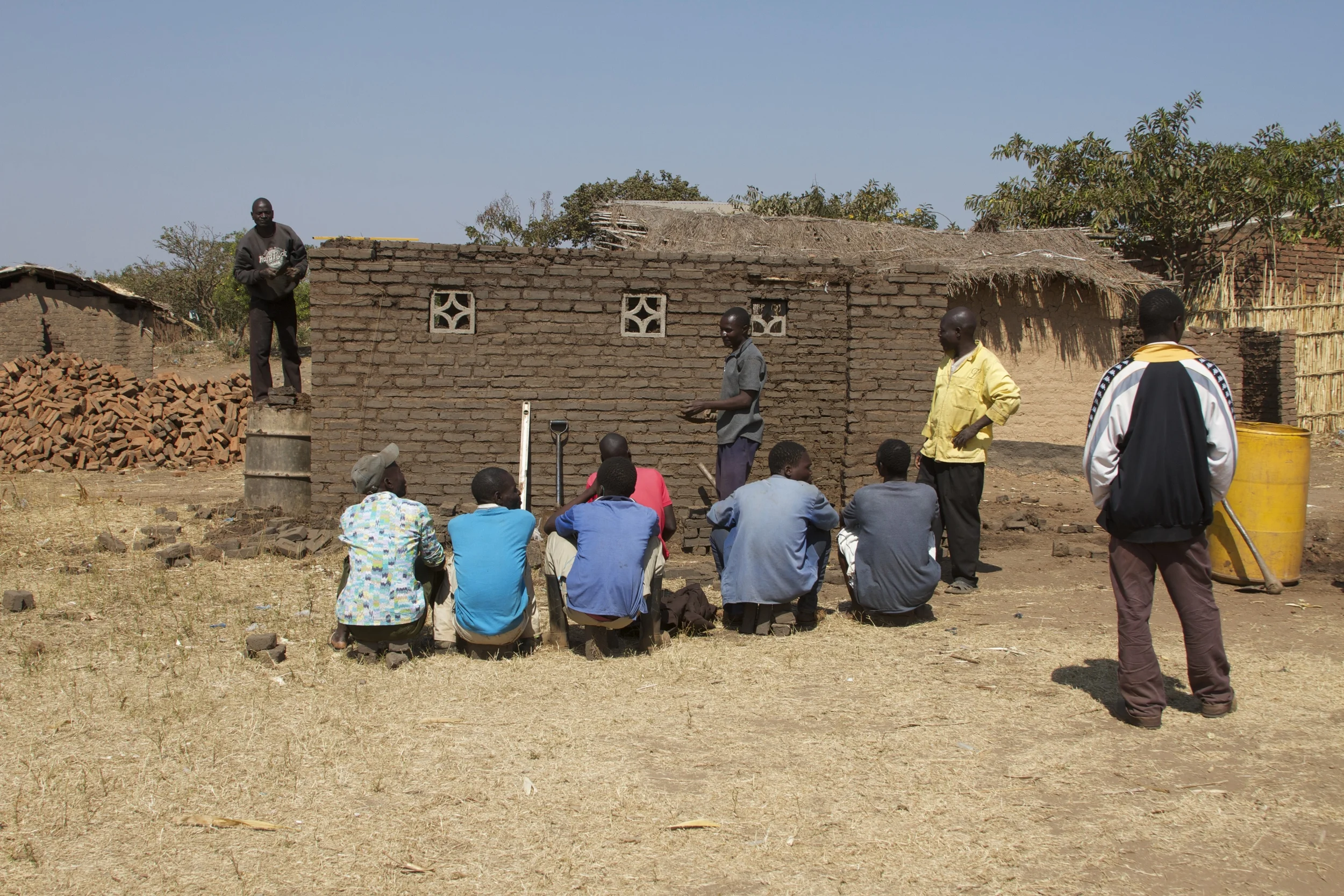 Building the new kitchen while teaching masonry to fellow villagers. 