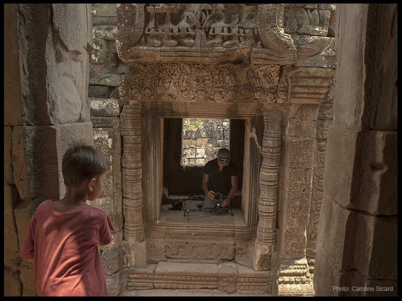 A young curious Cambodian boy looks curiously at the contraption.