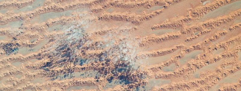Clouds cast shadows on Sahara Desert dunes