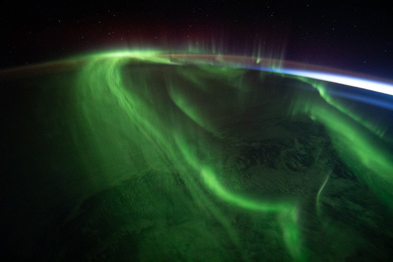 Aurora covers the Earth with stars above