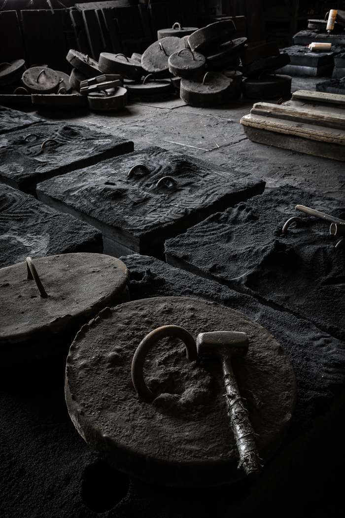Metal Pieces and a Hammer on the Foundry Floor