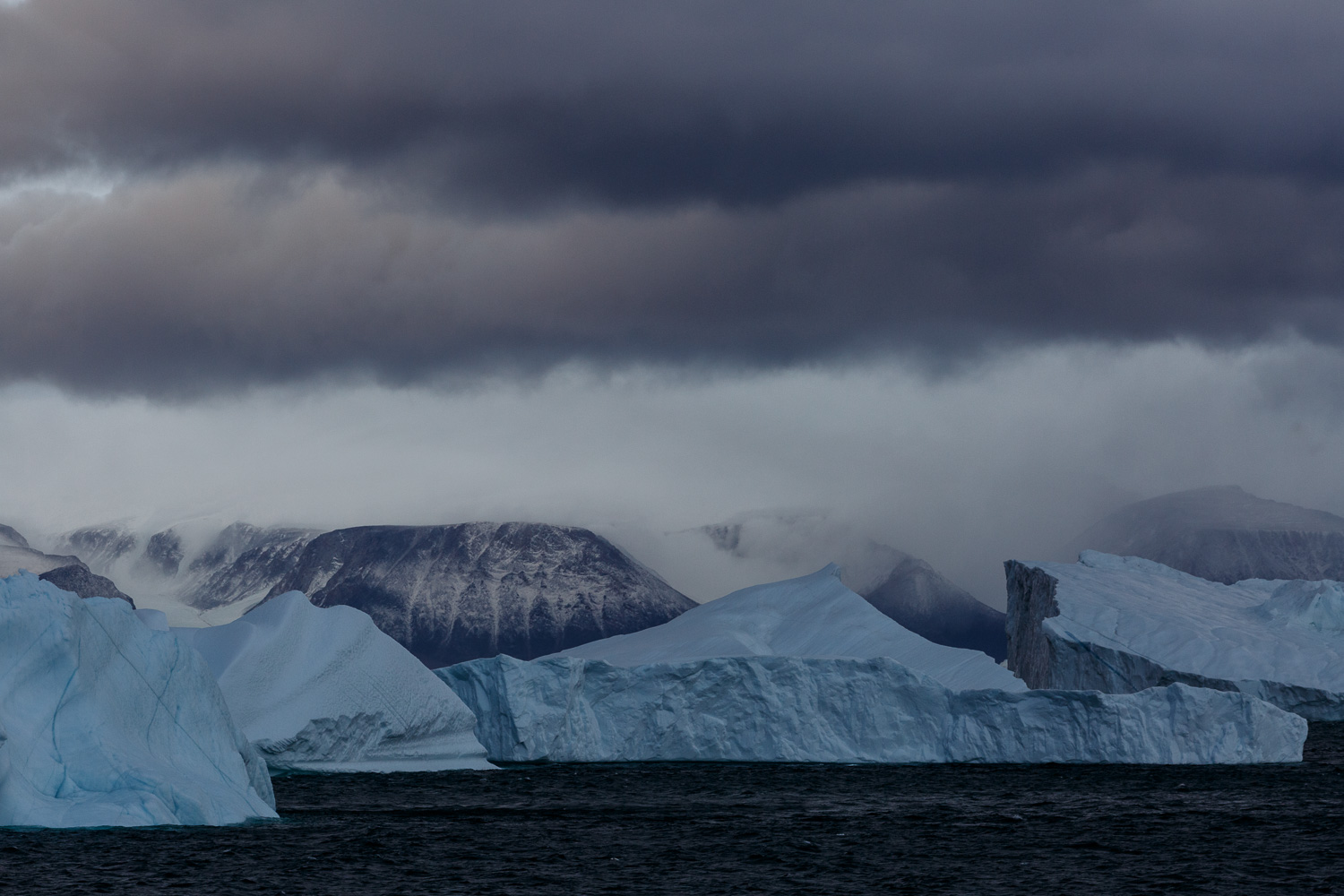 Icebergs, Mountains and Cloudy Skies