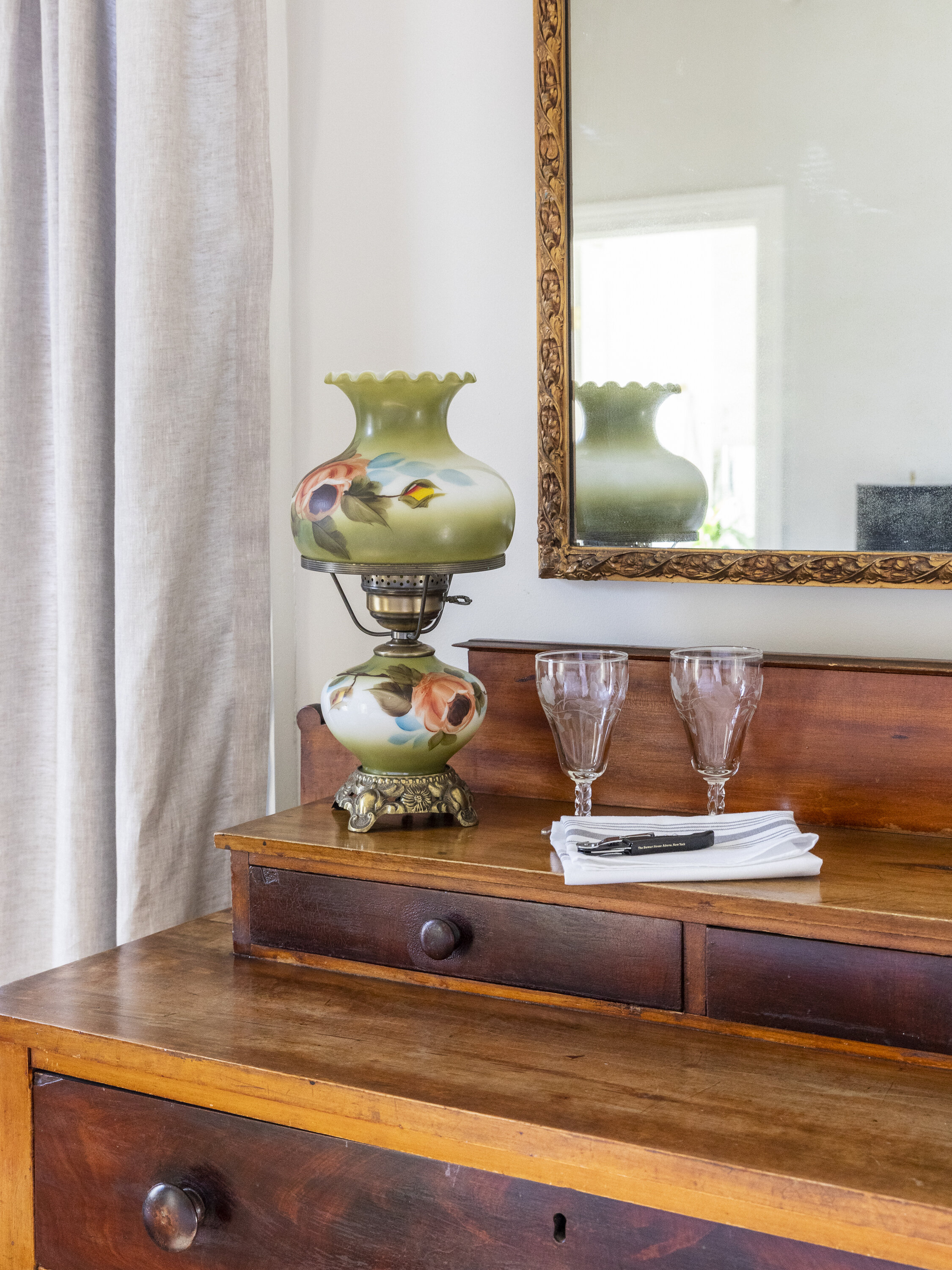 An antique lantern and dresser.