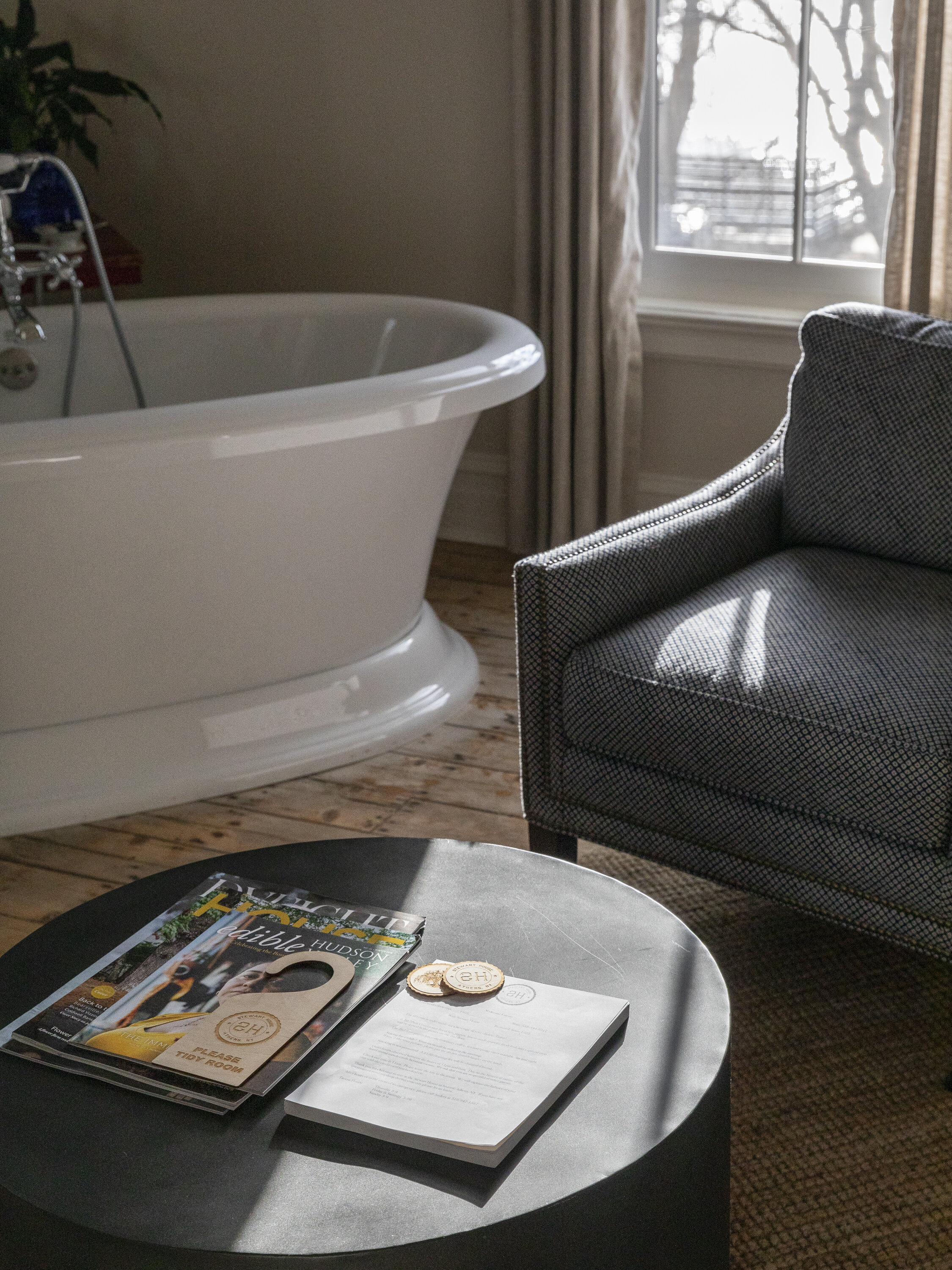 A soaking tub, chair and coffee table.