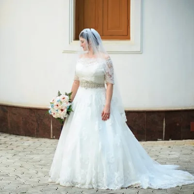 Profile of bride looking down at her bouqet of flowers.