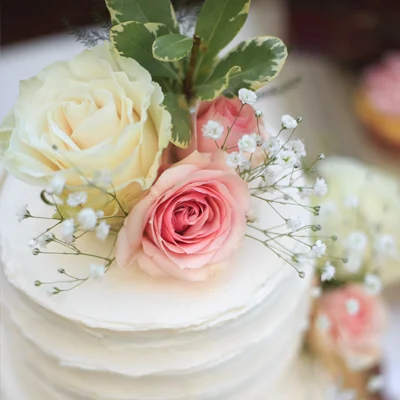White wedding cake with pink and white roses.