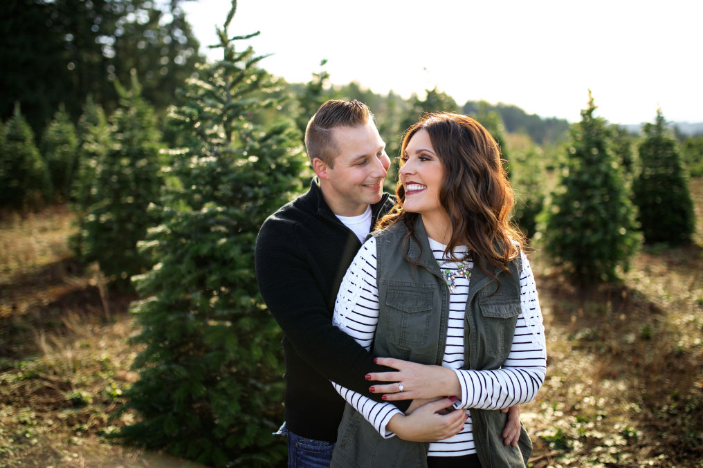 Man and women embracing at Christmas tree farm.