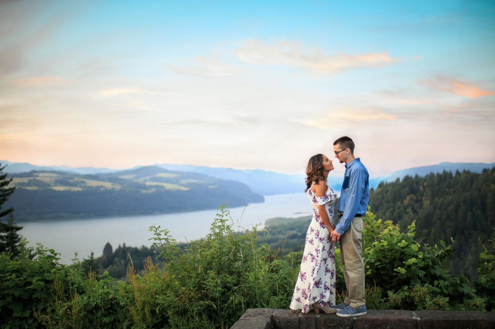 Man and woman smiling at each other at a Columbia River Gorge viewpoint.