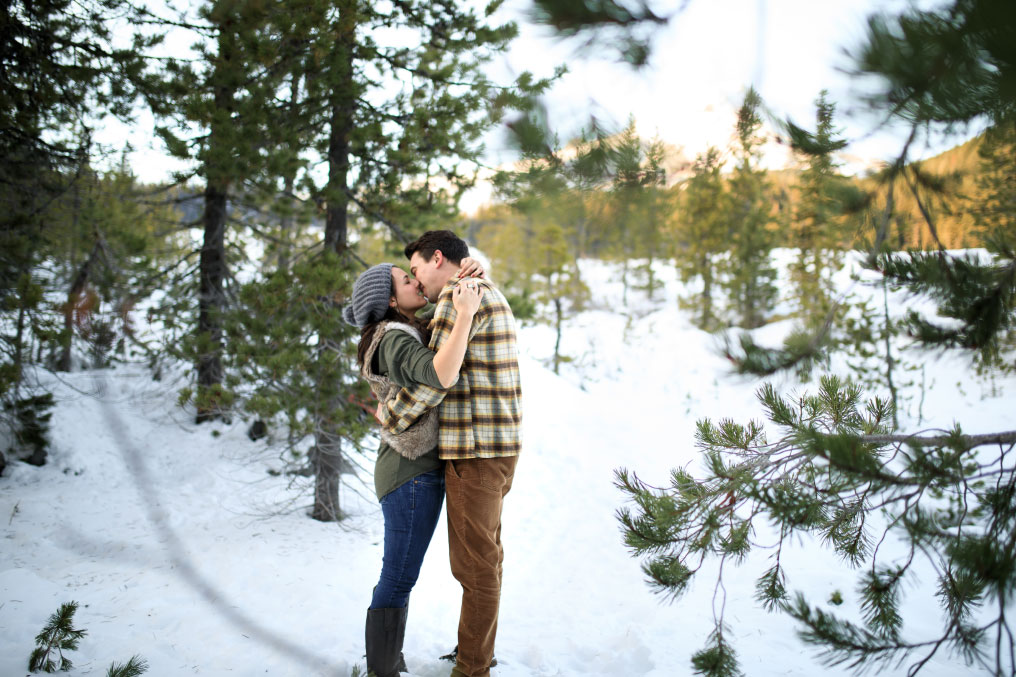 Man and woman embracing on snow covered Mt. Hood.