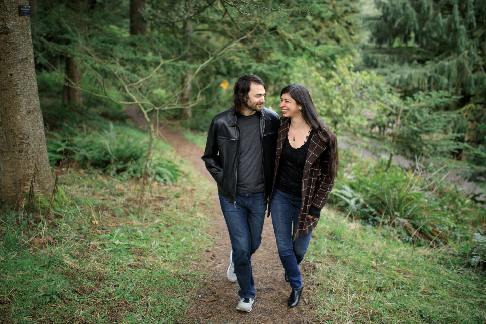  Man and woman walking together smiling in a forest park. 