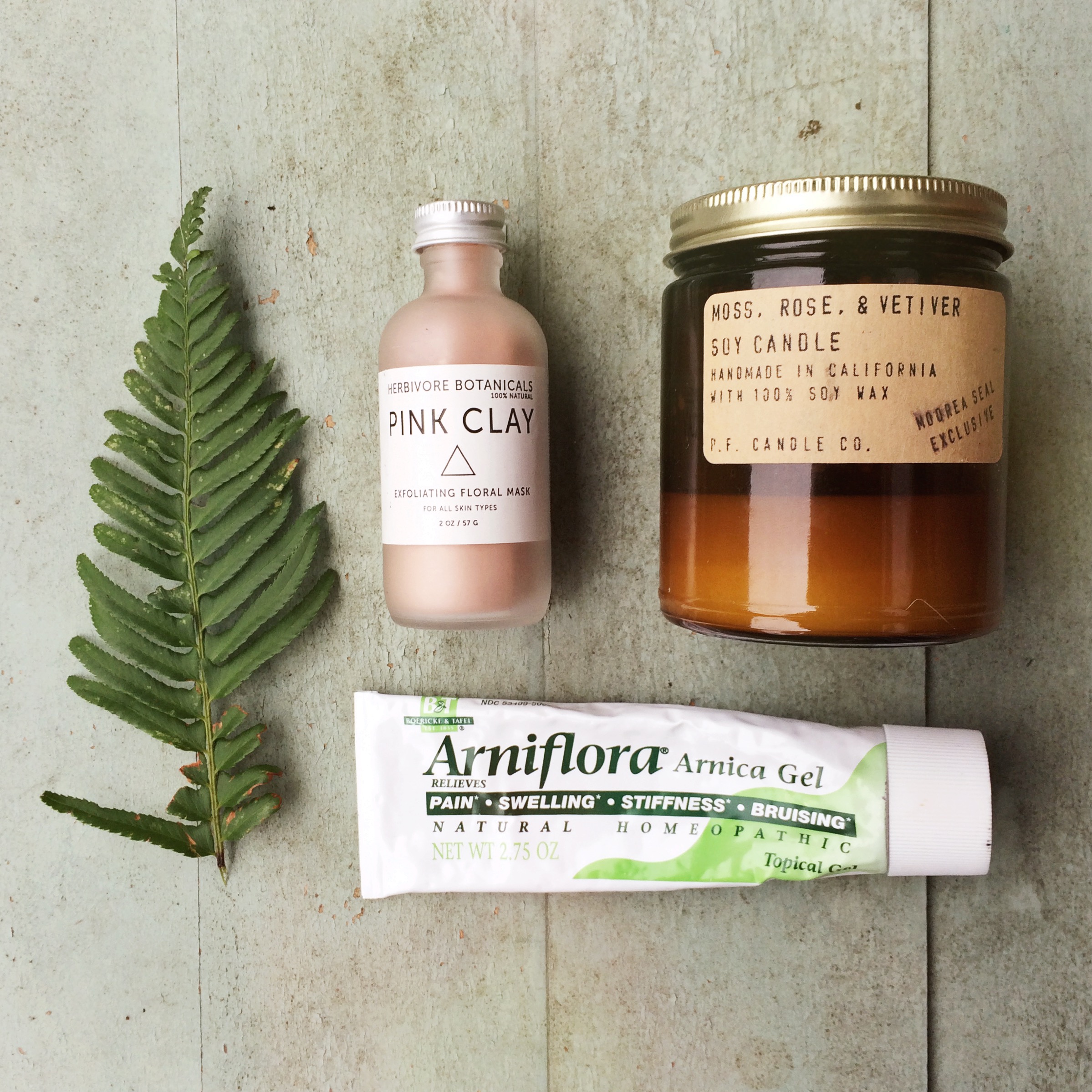 Some of our favorite recovery must-haves: A facial mask to help remove the post-workout sweat and grime, a soothing candle, and Arnica gel for bruises and sore muscles. Not pictured: Epsom Salts, Tiger Balm, supplements like curcumin and fish oil, and a foam roller.