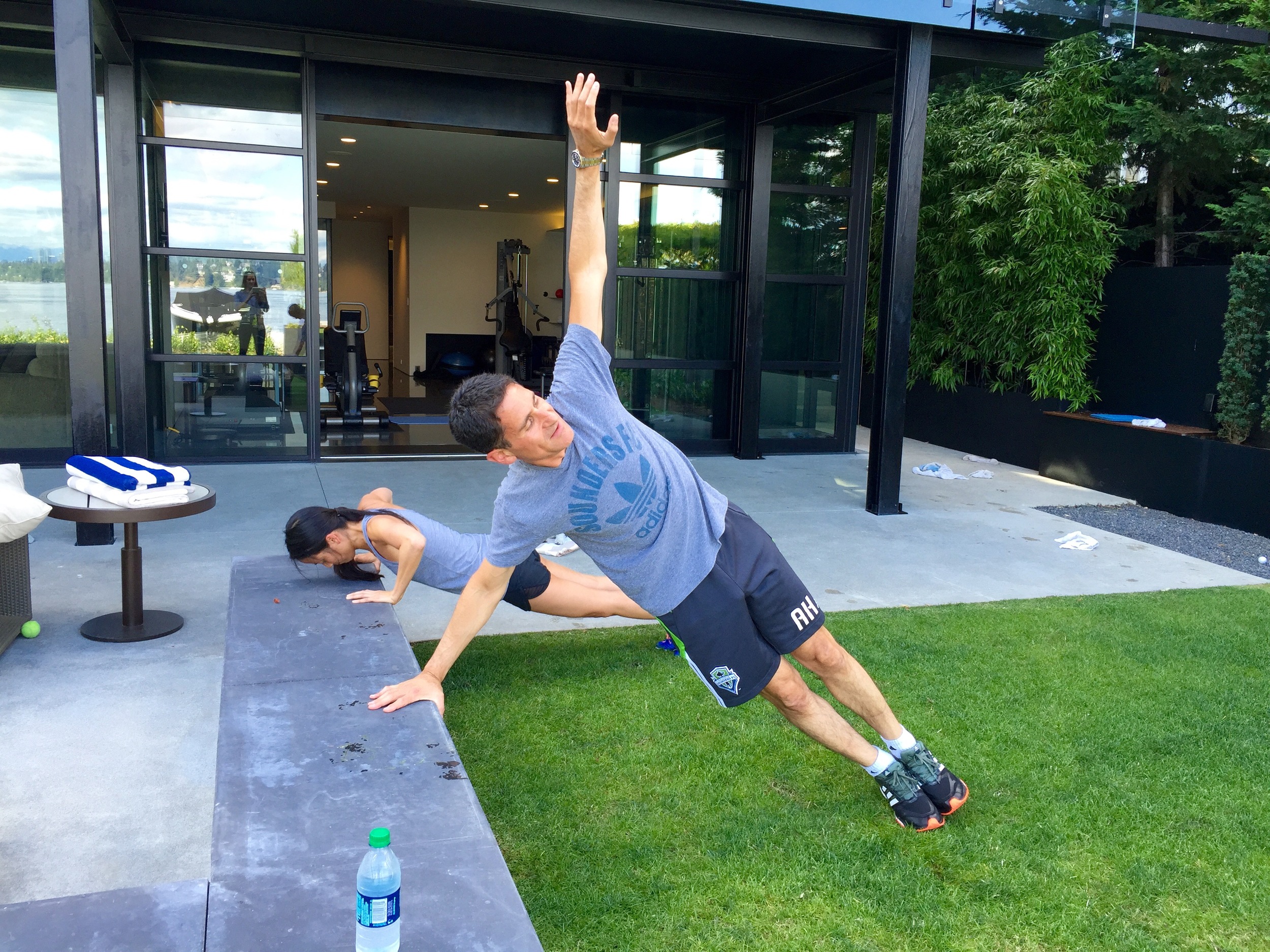 Wellness By Little clients Adrian and Khanh demonstrating side plank push ups in their Madison Park home. 