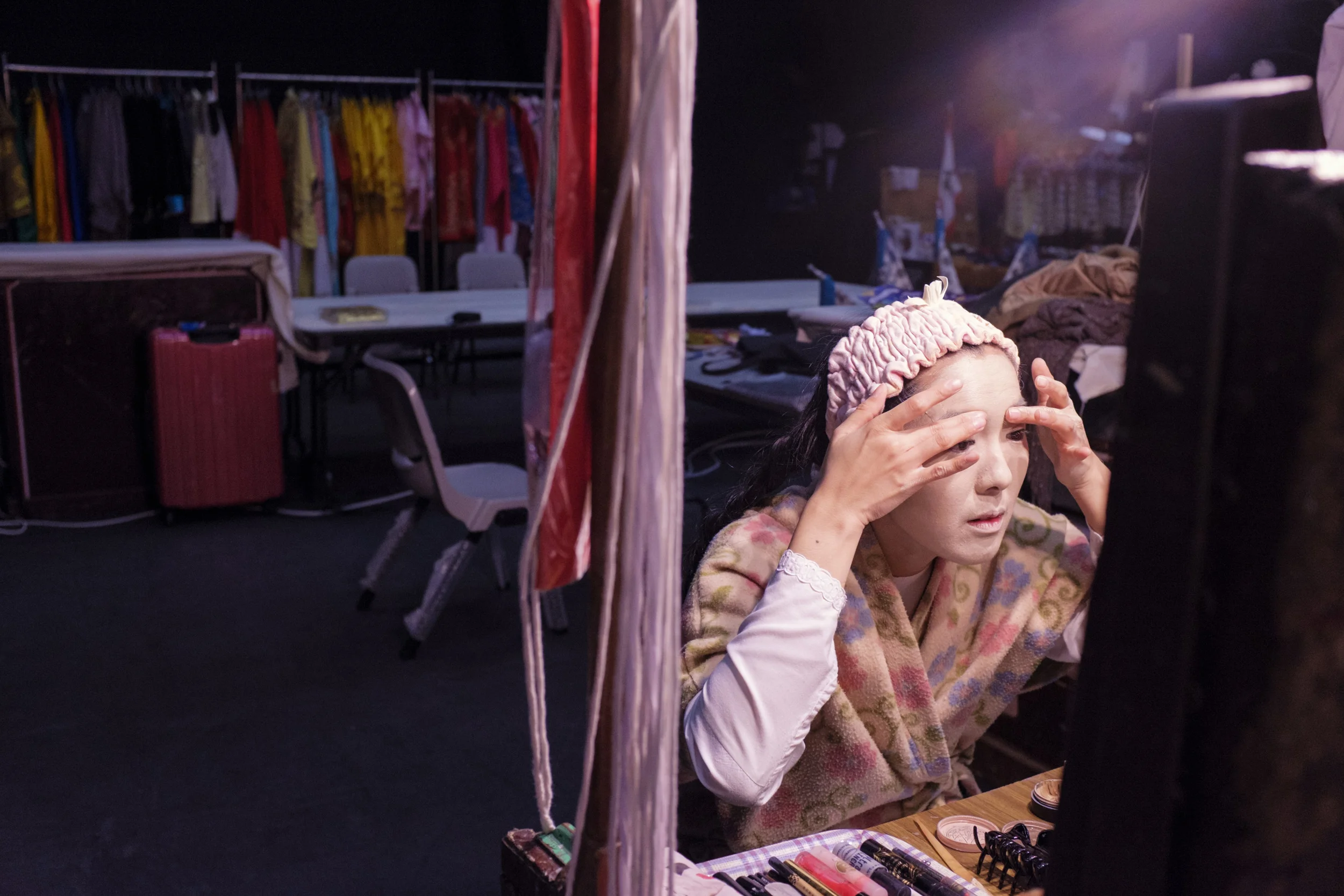  Eliza Li, Chinese Opera singer seen here applying makeup for her performance 