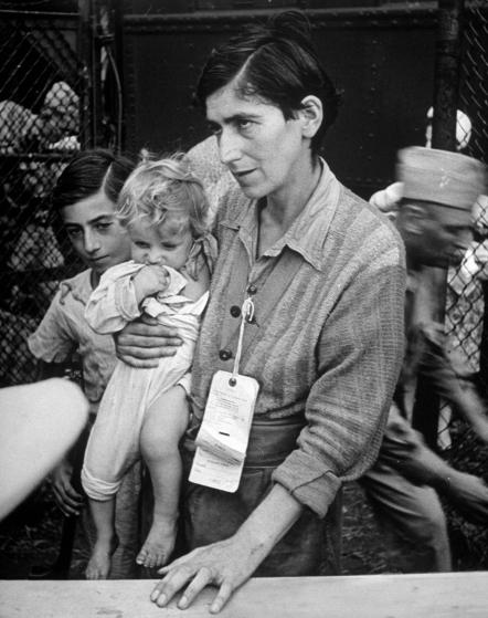 Eva Bass, formerly a night-club singer in paris, entering refugee camp in fort ontario, with her children yolanda and joachim, who she carried on a 60 km trek thru the fighting lines to reach an american transport ship (1944)