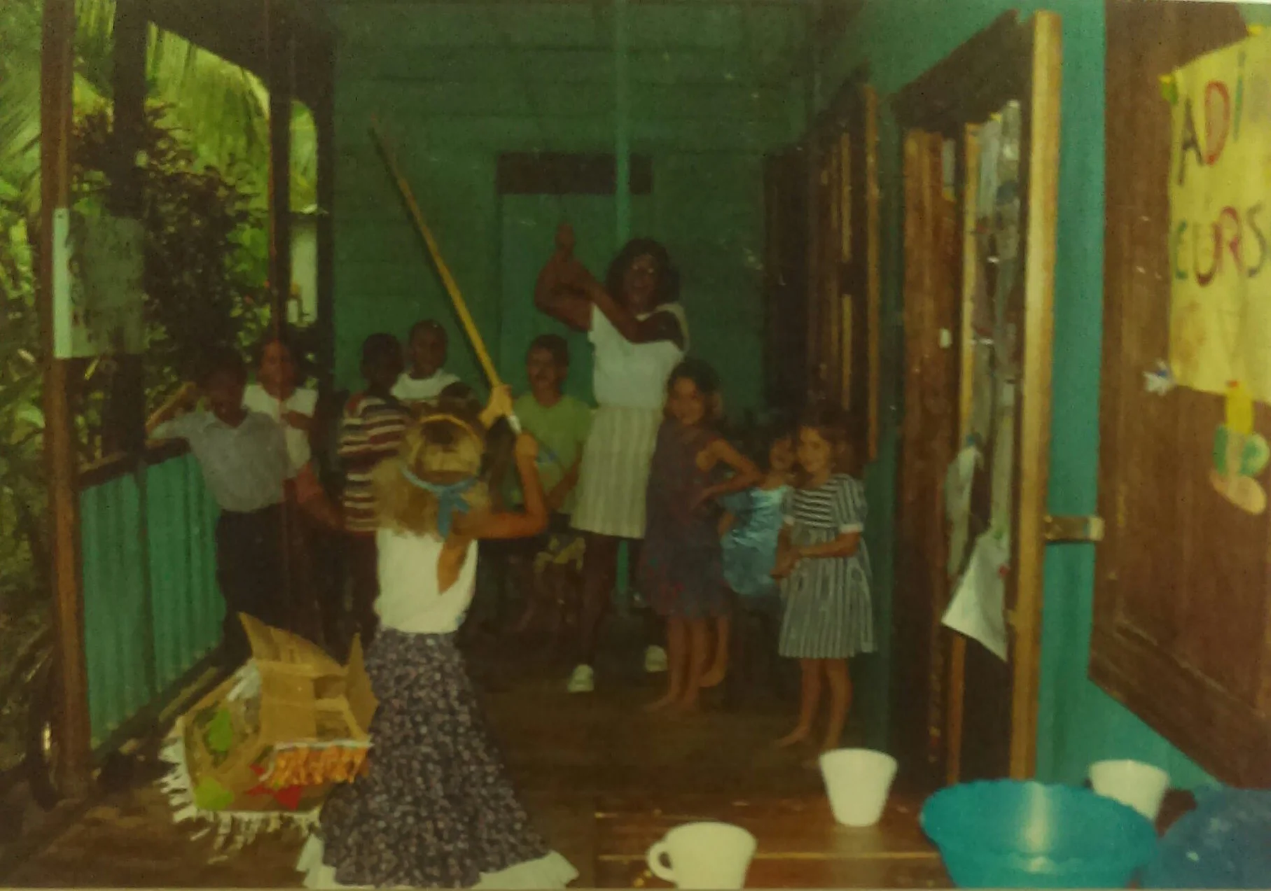 MD_001_008 Escuela del verano Punta Uva 2/1/1997 Unas maestras hicieron una escuela del verano en las cabinas de Selvin. Aqui Maestra Maria (de Peru) hace una fiesta, "Adios Curso del Verano" Simone Bryan ataca la pinata. Estan presente Jackie Bryan, Markus Brown, David W., Kendra Zingrich, Ana y Nina y otros.