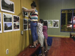 Students hang photographs from the South Caribe Roots Archive for a local gallery at the Casa de la Cultura