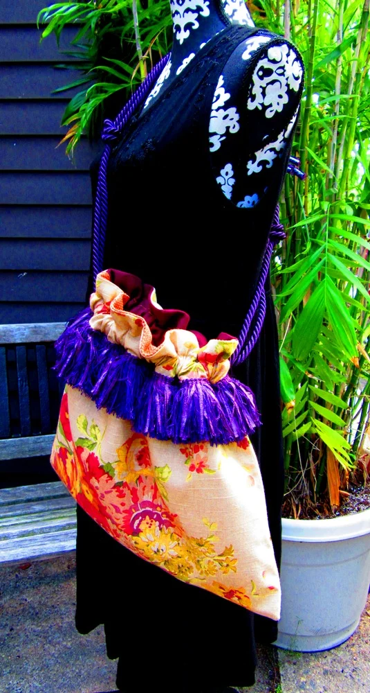 large tote bag with flower designs lined with purple fringe