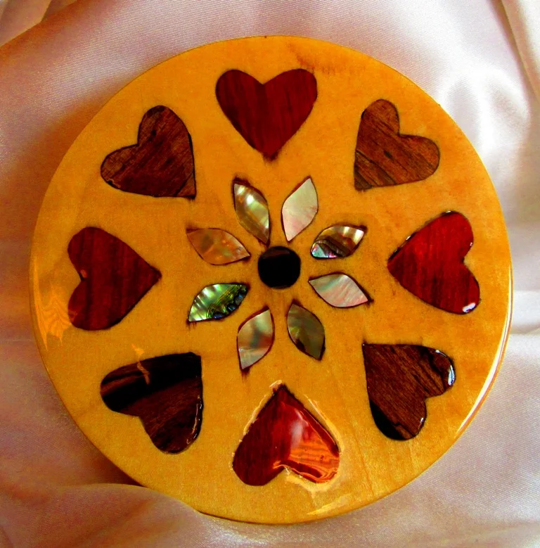 Poplar circle with redheart, black and white ebony heart inlays and abalone and golden pearl inlays and rosewood center