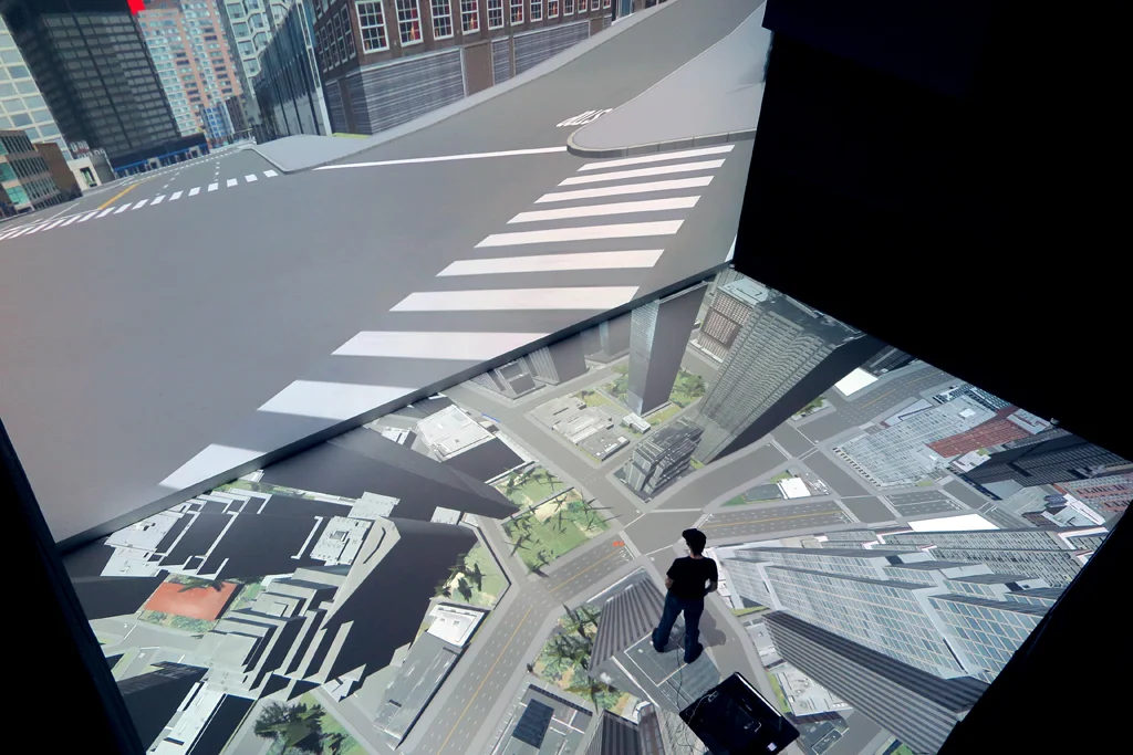 The simulation of an urban landscape within Deep Space 8K and a team member walking the virtual city. Source: TUMCREATE + Ars Electronica