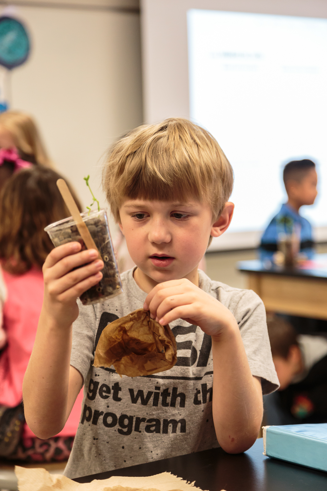 A group of 2nd grade students researched and set up different growing stations to test variables that affect the growth of pea plants.