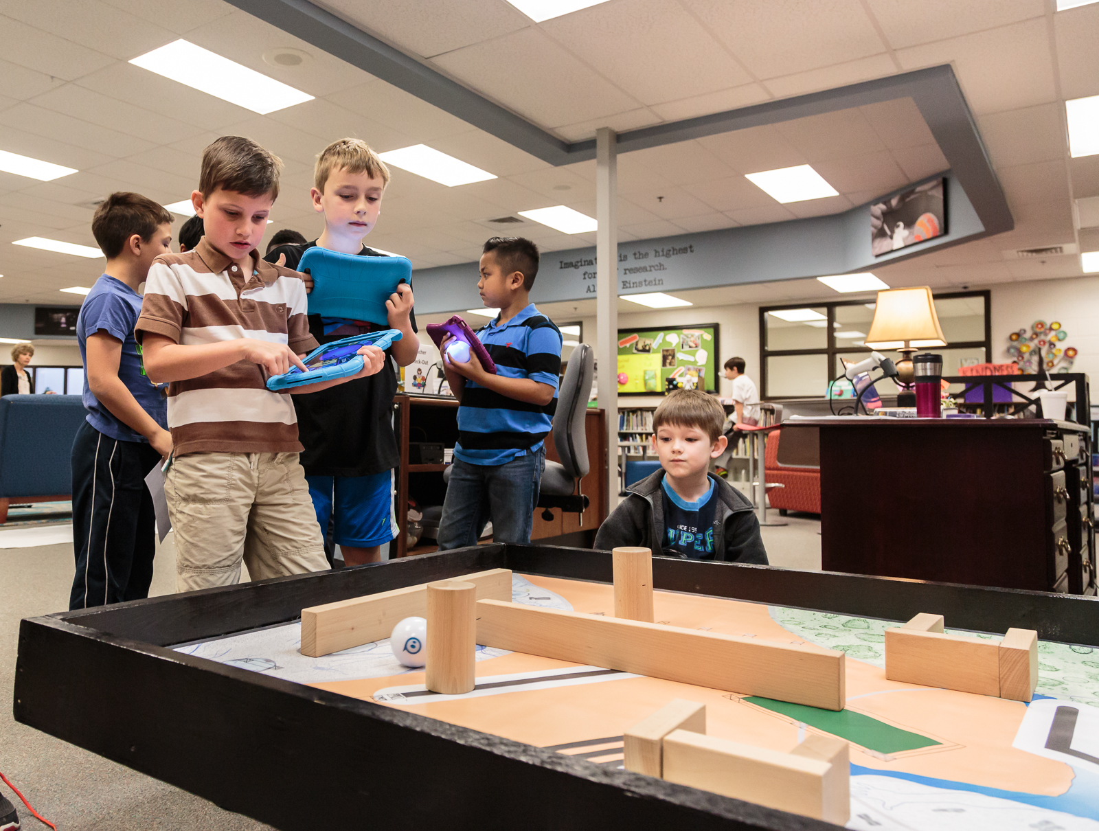   A group of 2nd grade students took turns using a tablet acting as a remote control to guide a motorized robot ball through a maze of wooden blocks. “The speed and the power made it pretty hard,” says  Cody .  