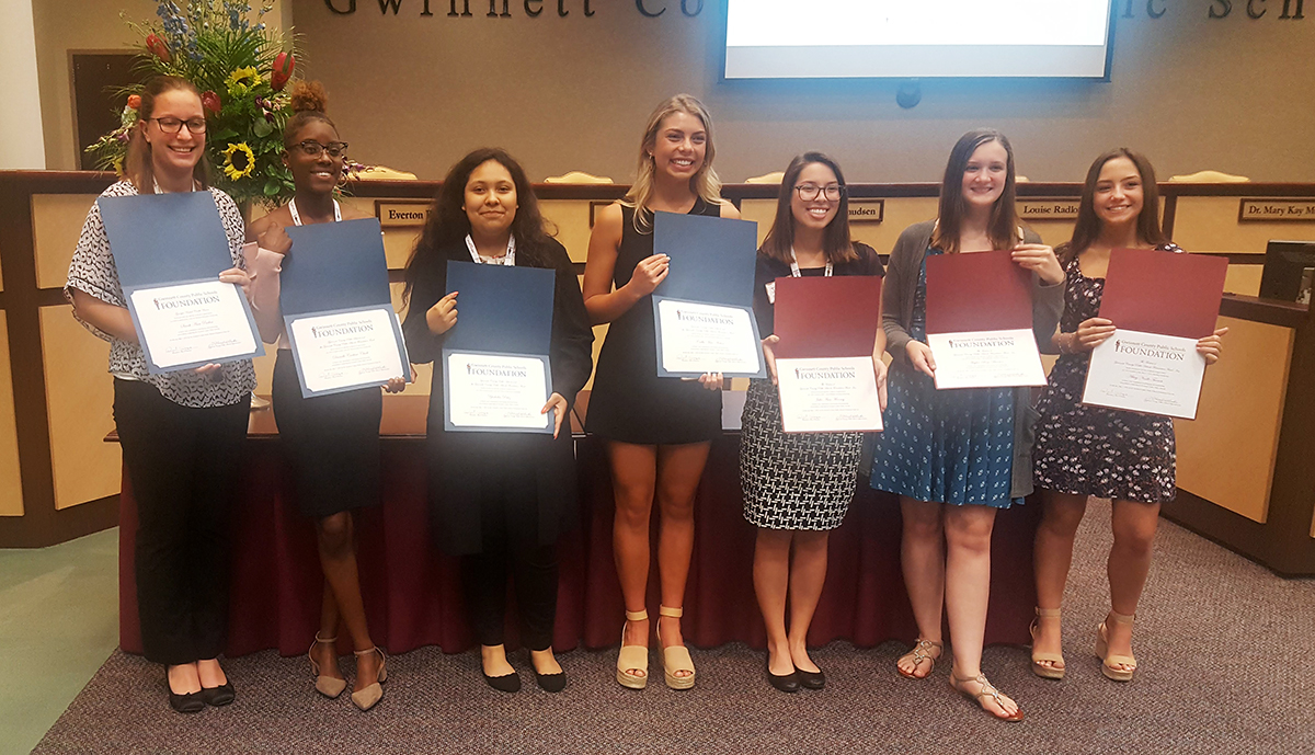 Students show scholarships for future educators.