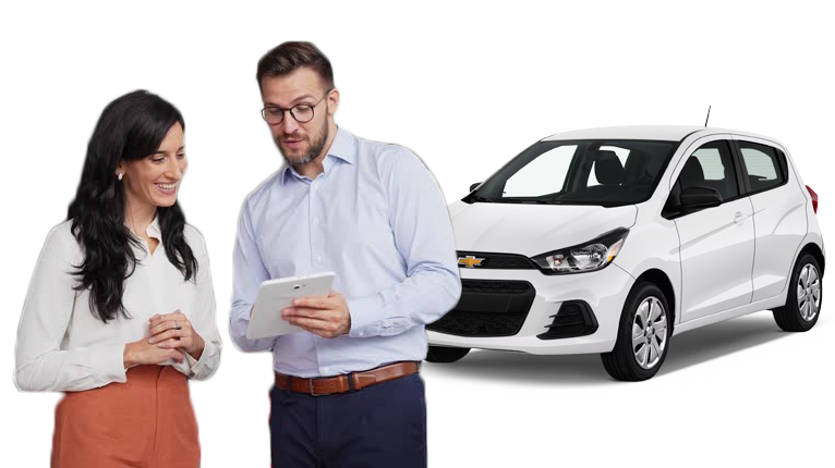 A male salesperson and a female customer standing in front of a 2017 Chevy Bolt. The male salesperson is holding a tablet, showing the female customer options available to her via the showroom application.