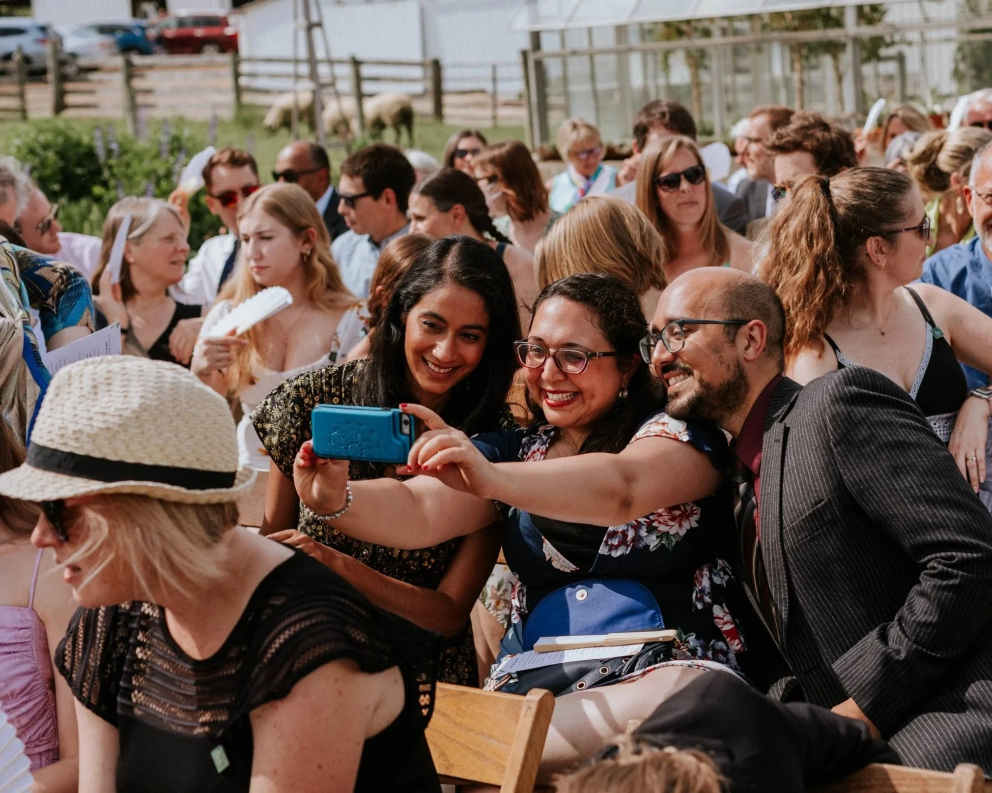 A group of people at an outdoor event taking a selfie together, with many smiling and posing.
