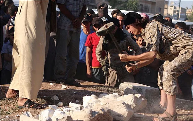 An Islamic State militant destroys ancient artifacts in the ancient Syrian city of Palmyra, Syria on July 2, 2015.