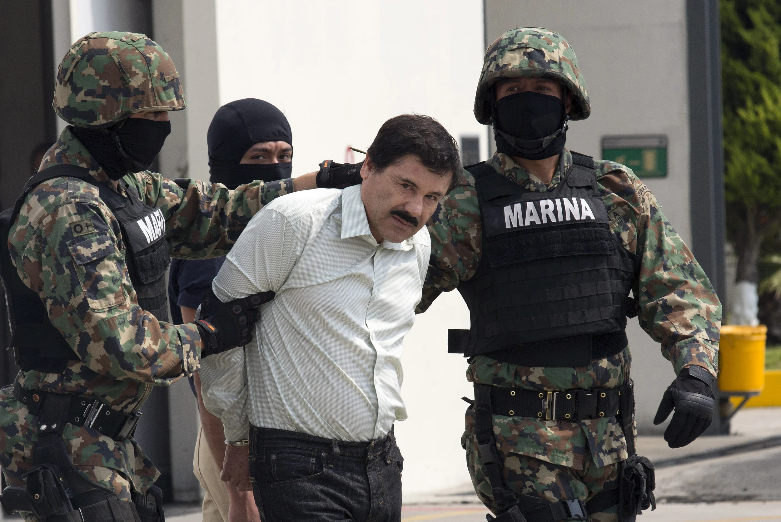 El Chapo handcuffed by navy marines in Mexico City, AP 2015