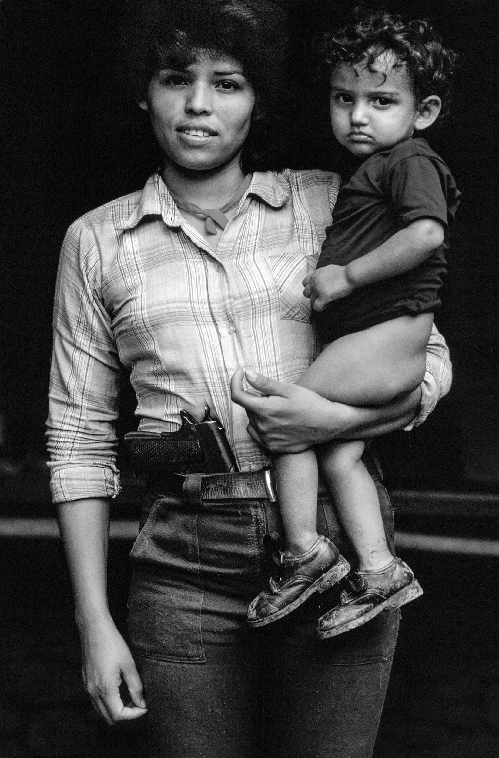 Teresa de Jesus Serrano, aged 22, with her young son. She made uniforms for the FPL guerrillas. Chalatenango, February 1984. 
