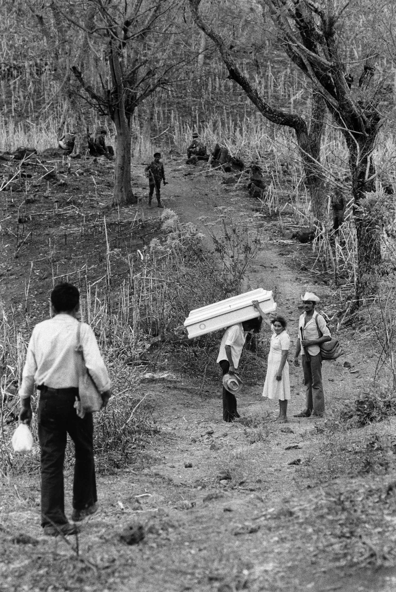 A family collect the body of their daughter - killed during a Salvadoran Air Force bombardment around the town of Carolina, Morazan. Badly injured, she had been evacuated by the army but was returned three days later in a coffin, March 1984. 