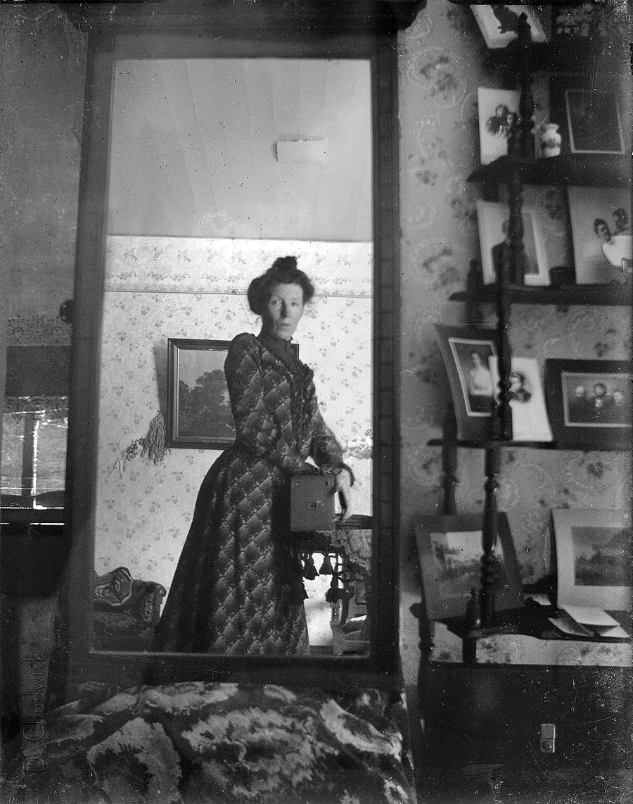 Photographer Margrét Möller taking a self-portrait using a mirror and a box camera, circa 1900.