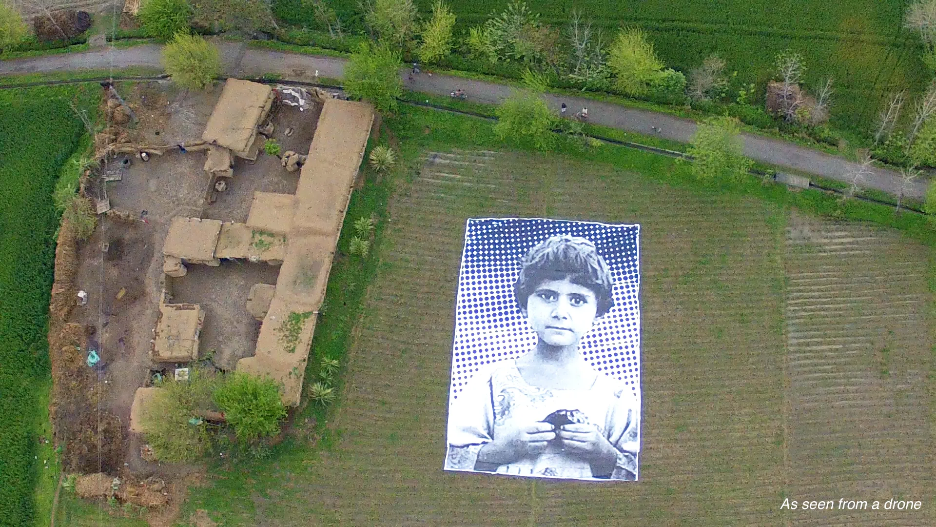 A poster bearing the image of a Pakistani girl whose parents were killed in a drone strike, lies in a field at an undisclosed location in the northwestern Khyber-Pakhtunkhwa province. Photo source: # NotABugSplat /AFP/Getty Images.