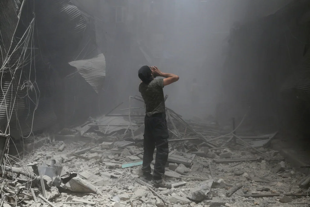 A Syrian man after a reported airstrike by Syrian government forces in Bustan al-Qasr, a rebel-held neighbourhood. Photo by Baraa Al-Halabi.