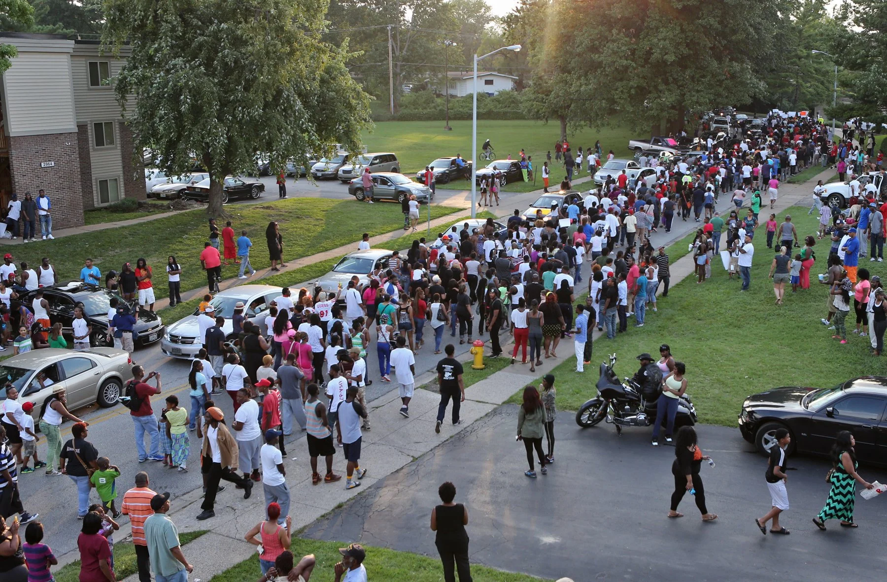 A large crowd of protesters marches out of the apartment complex on Sunday evening, Aug. 10, 2014, in Ferguson, towards W. Florissant, as they protest the shooting of Michael Brown. Photo by J.B. Forbes.