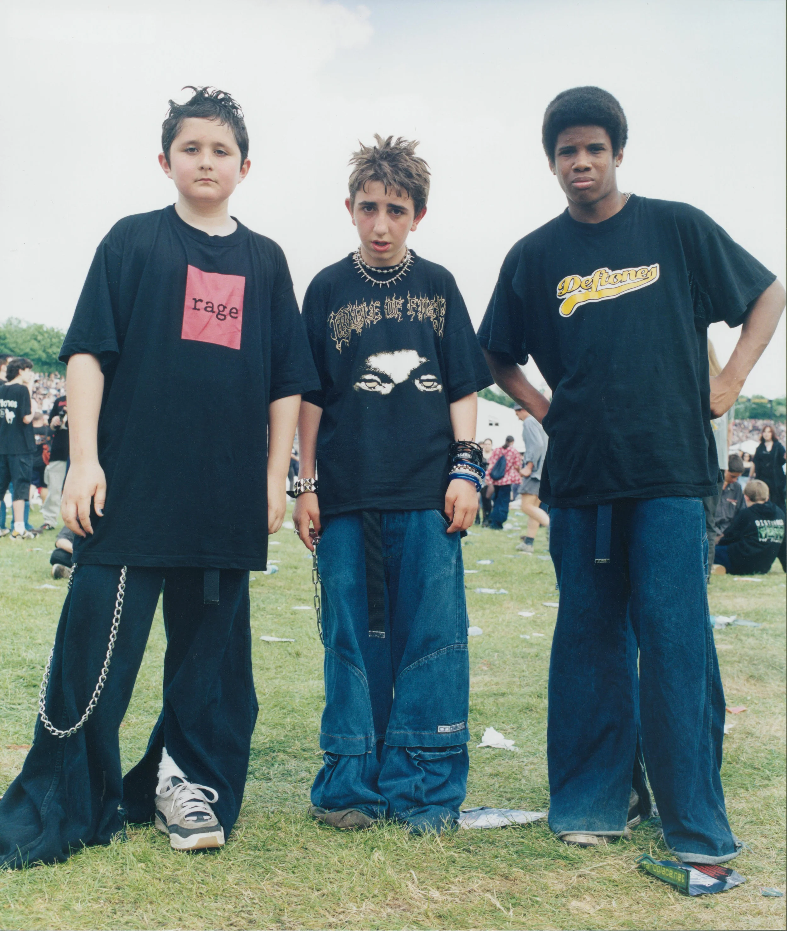 Three young punk rockers standing slouched forward posing at a music festival. Photo source: Youth Club Archive .